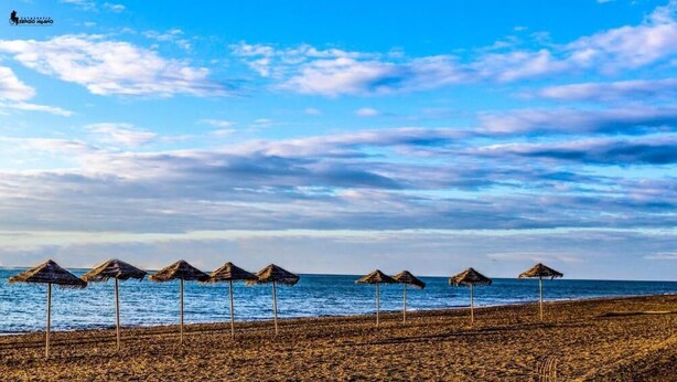 A beach with thatched umbrellas and a clear sky. - Las Yucas  (Velez-Malaga)