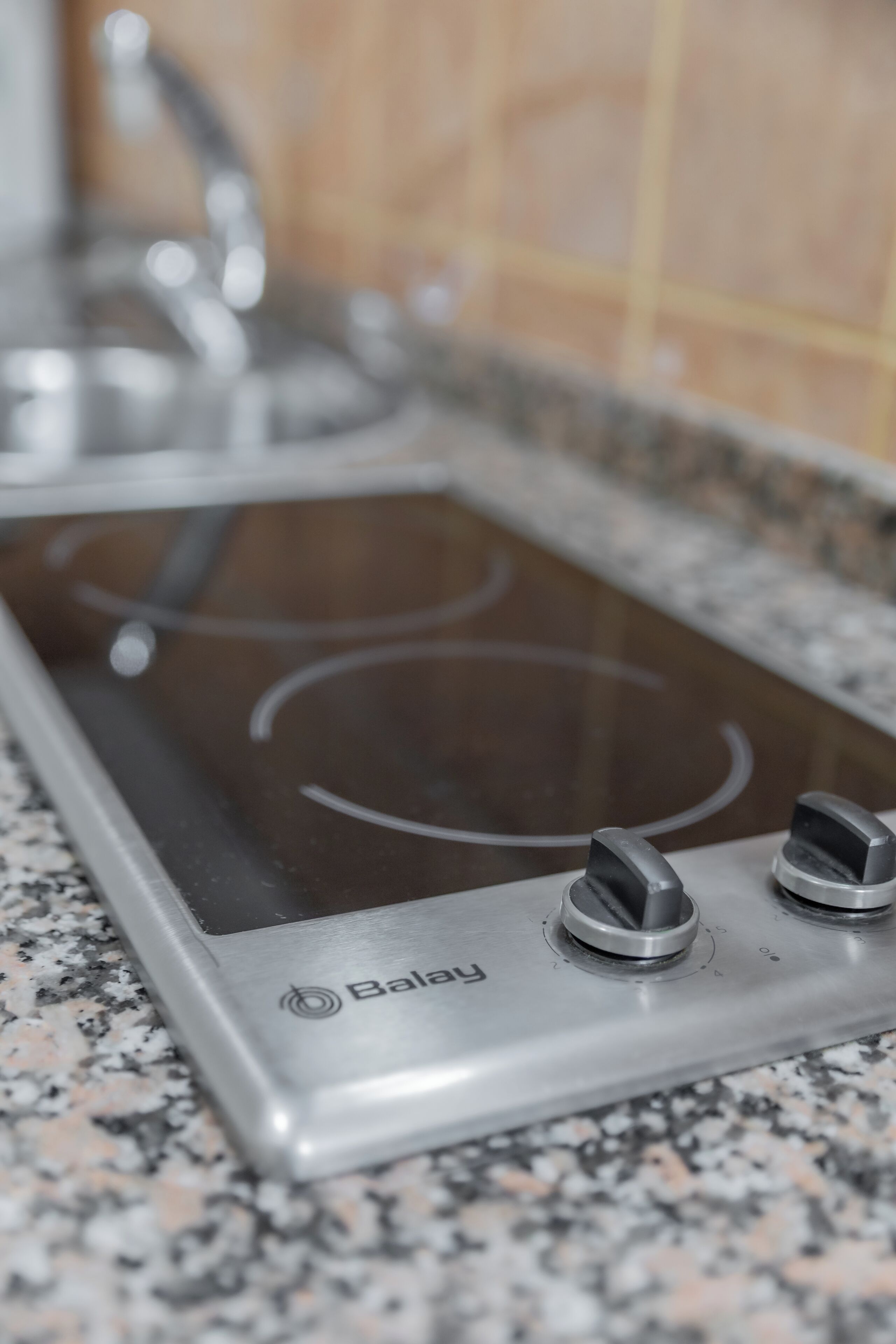 A kitchen with a Baxi induction cooktop and a granite countertop.