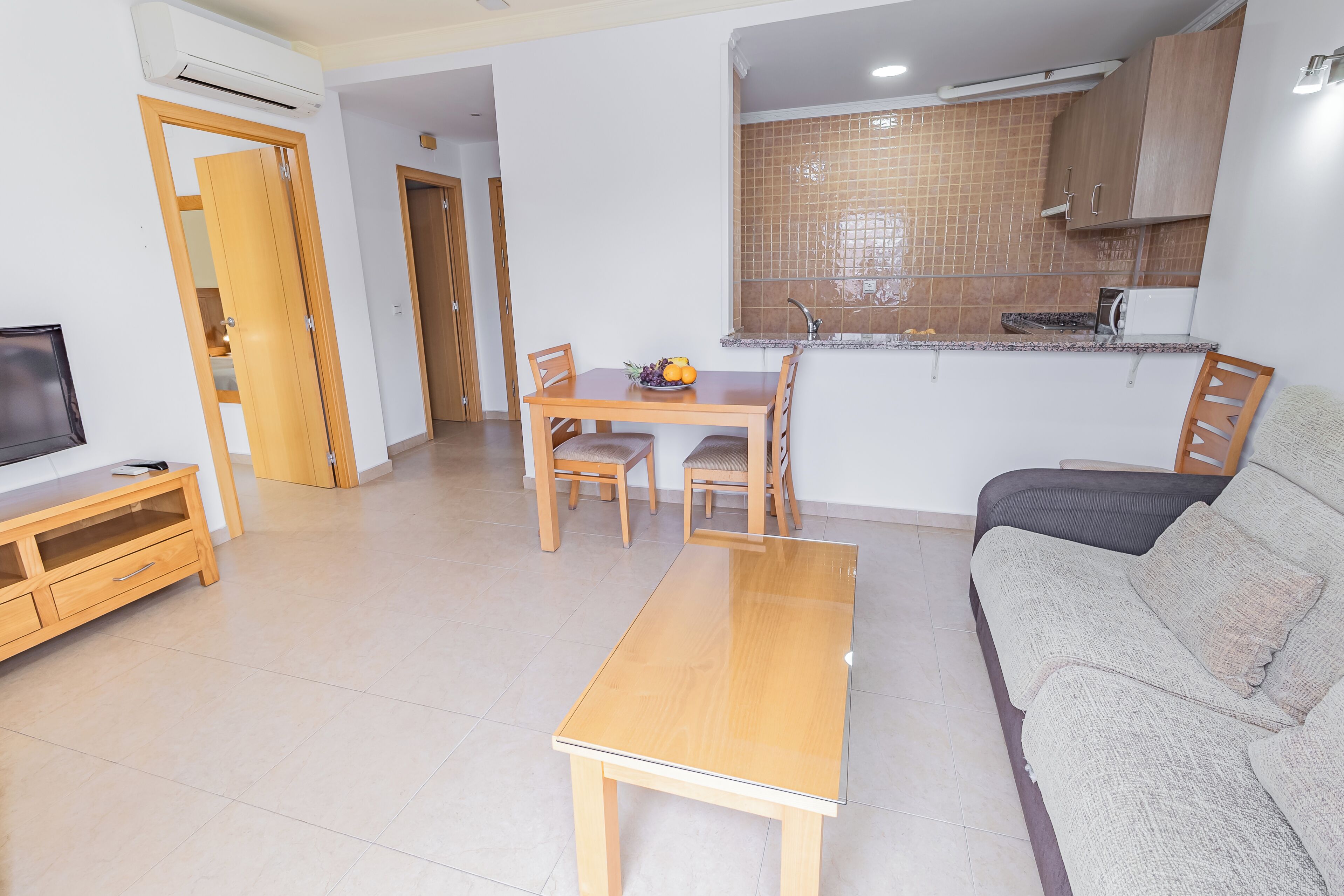 Un espace de vie compact comprenant un coin repas, une kitchenette et un coin salon.