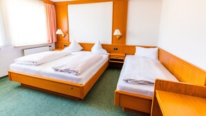 A hotel room with two beds, a wooden headboard, a green carpet, and a window with curtains. - Gasthof Pension Post (Denkendorf)