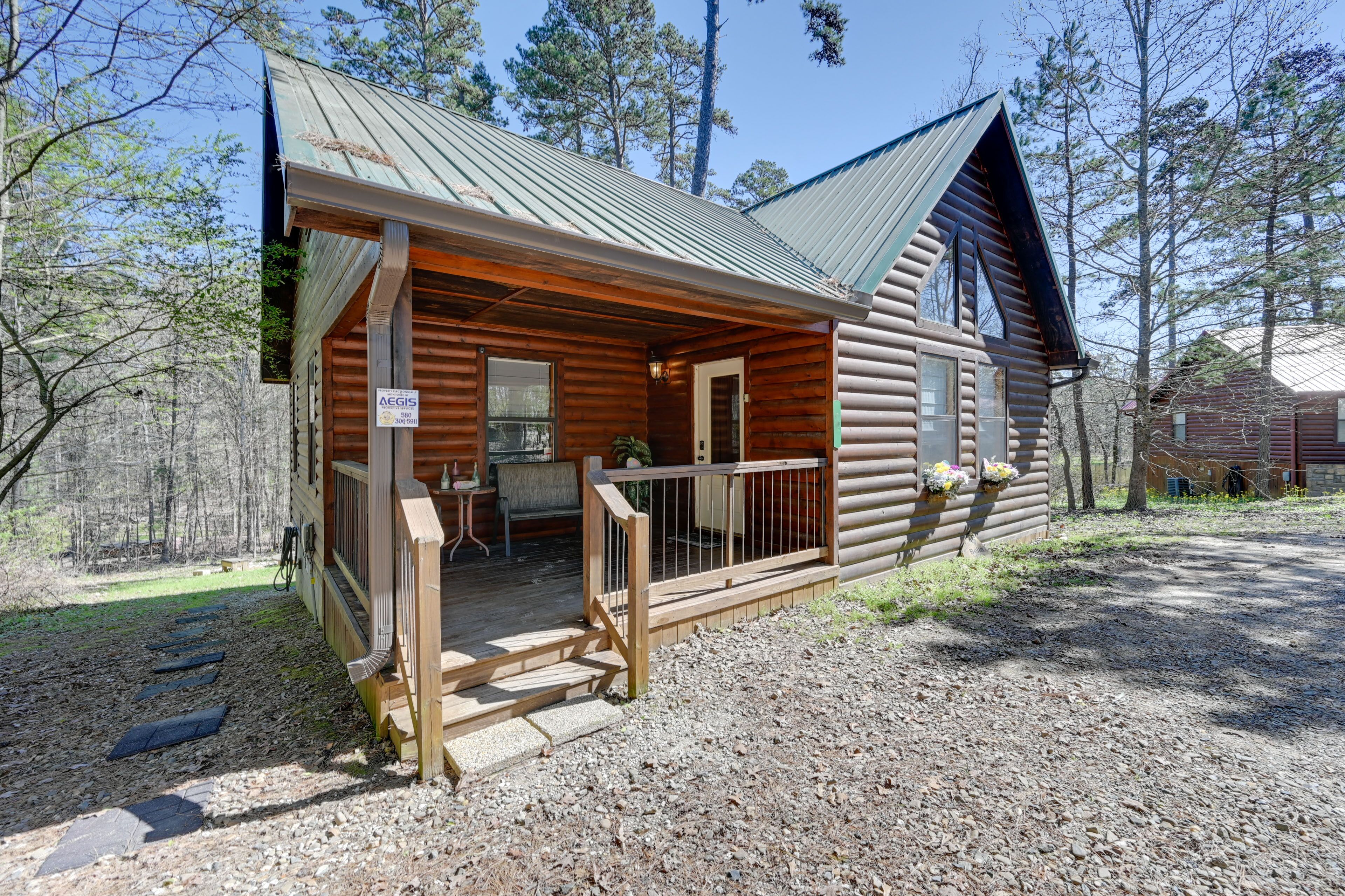 A log cabin with a porch, a dining area, and a small outdoor seating space.
