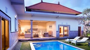 A modern house with a swimming pool, outdoor seating, and a well-lit interior. - Prime location just walking distance to the Boutique shop, Restaurant , Bar (Seminyak)