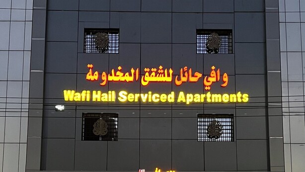 Un edificio con un cartel que indica que es un complejo de apartamentos con servicios.