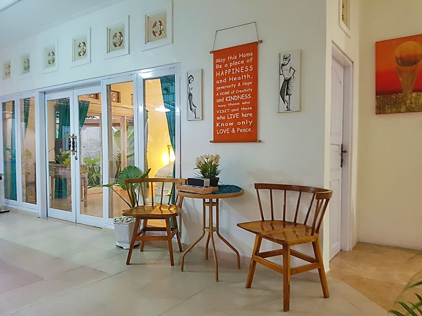 A room with a table and chairs, a door, and a wall with a poster.