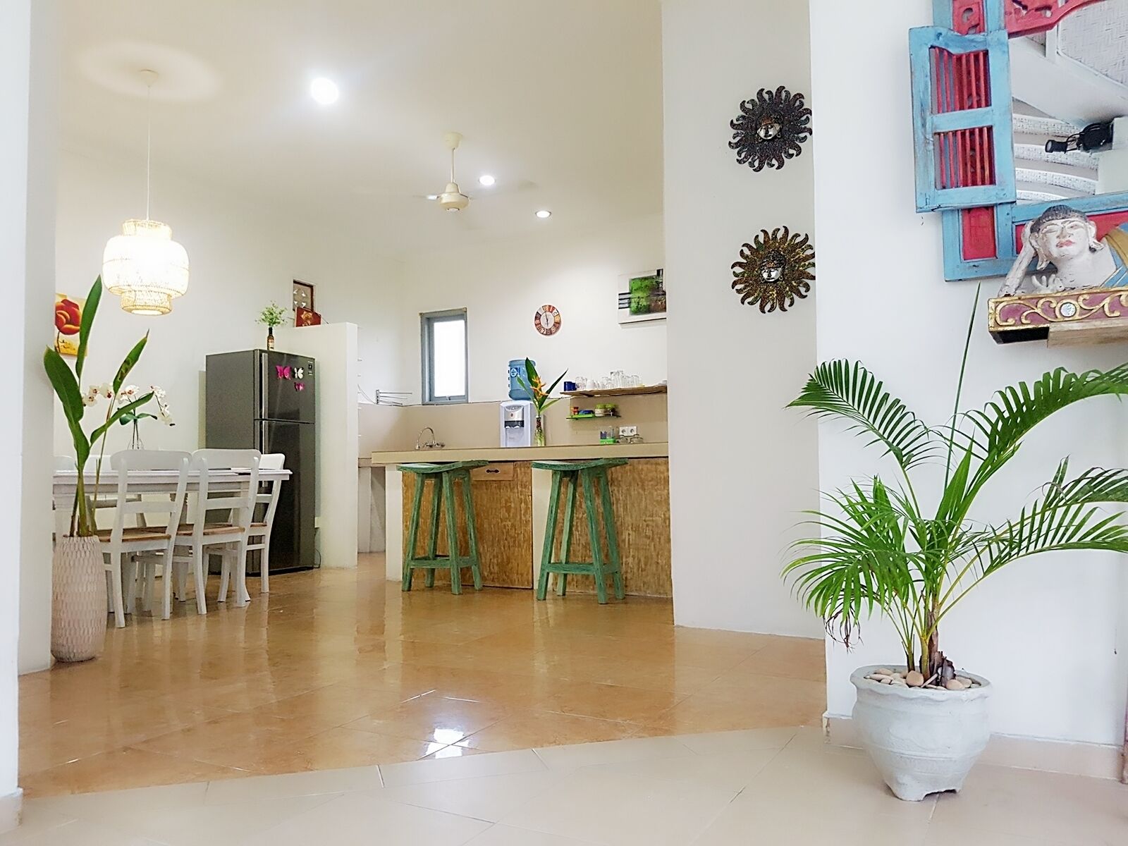 A spacious kitchen with a dining area, a refrigerator, and a water dispenser.