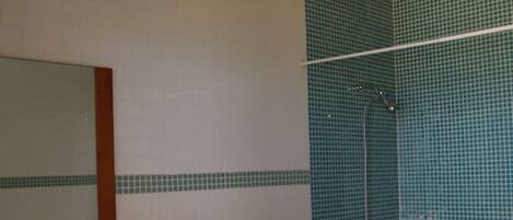 A bathroom with a toilet, sink, and shower.