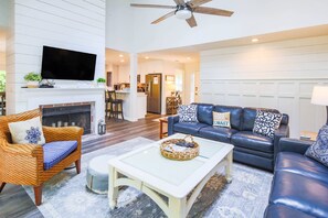 Cozy living room with a fireplace, flat-screen TV, and comfortable seating area.