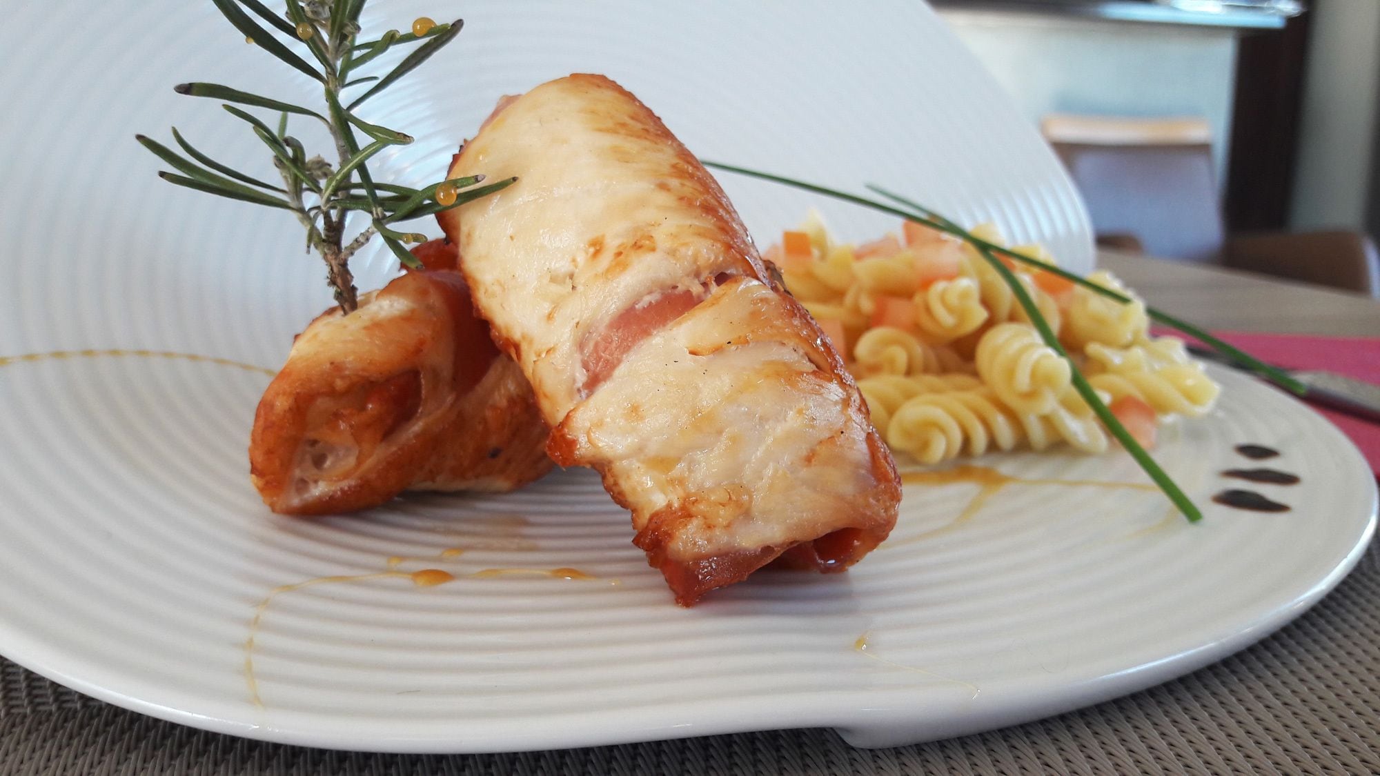 Een bord met vlees, mogelijk spek, en pasta.
