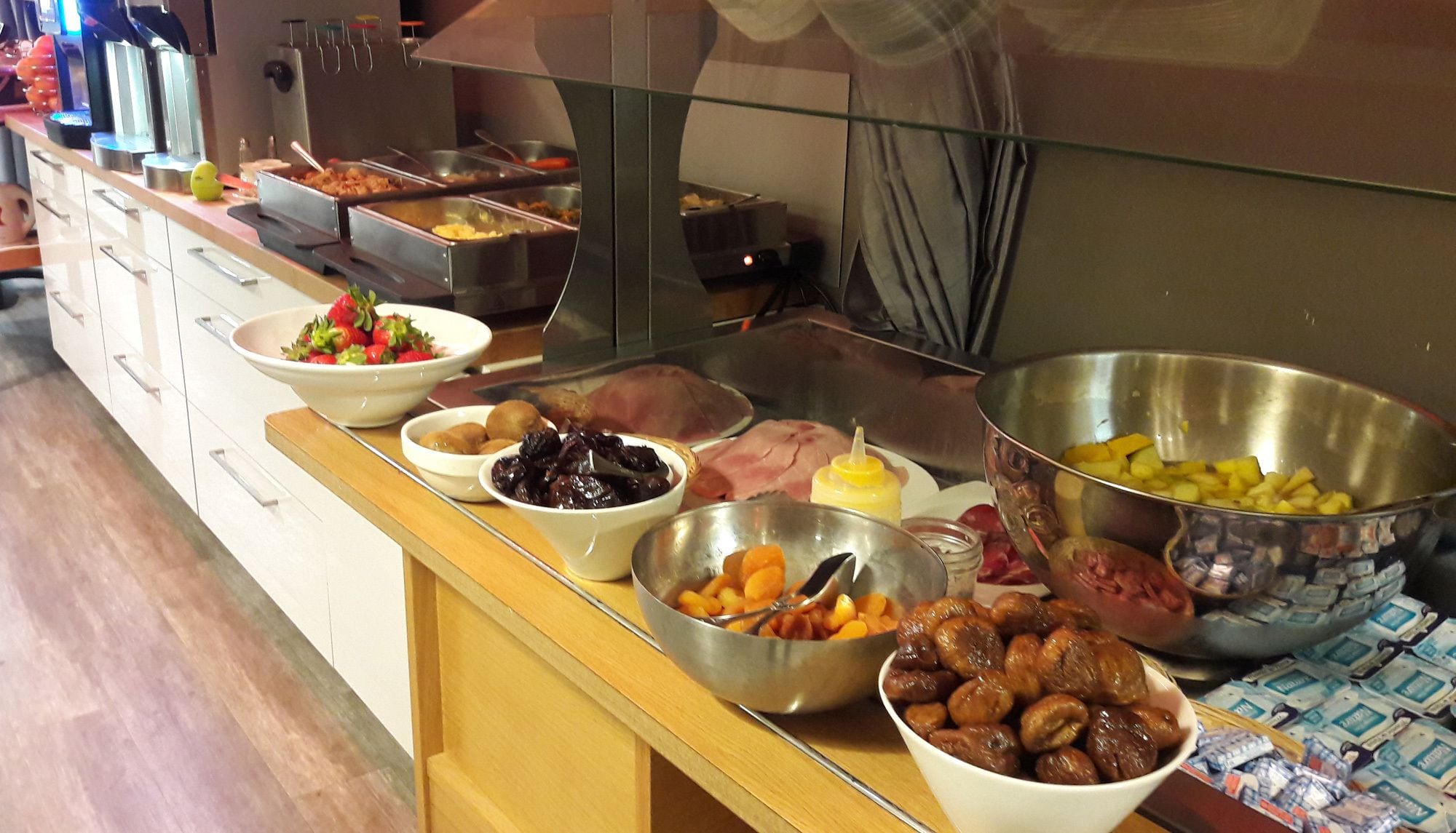 A buffet with various food items including fruits, vegetables, and meats.