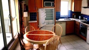A compact kitchen with a dining area, a washing machine, and a small seating area. - Comfortable, Modern, Luxury, Secure, Beachfront, Seafront, City Centre (Galway)