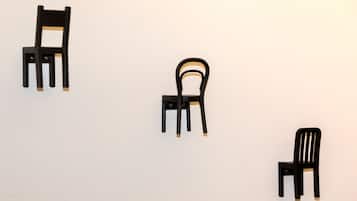 Drie zwarte stoelen voor een effen muur.