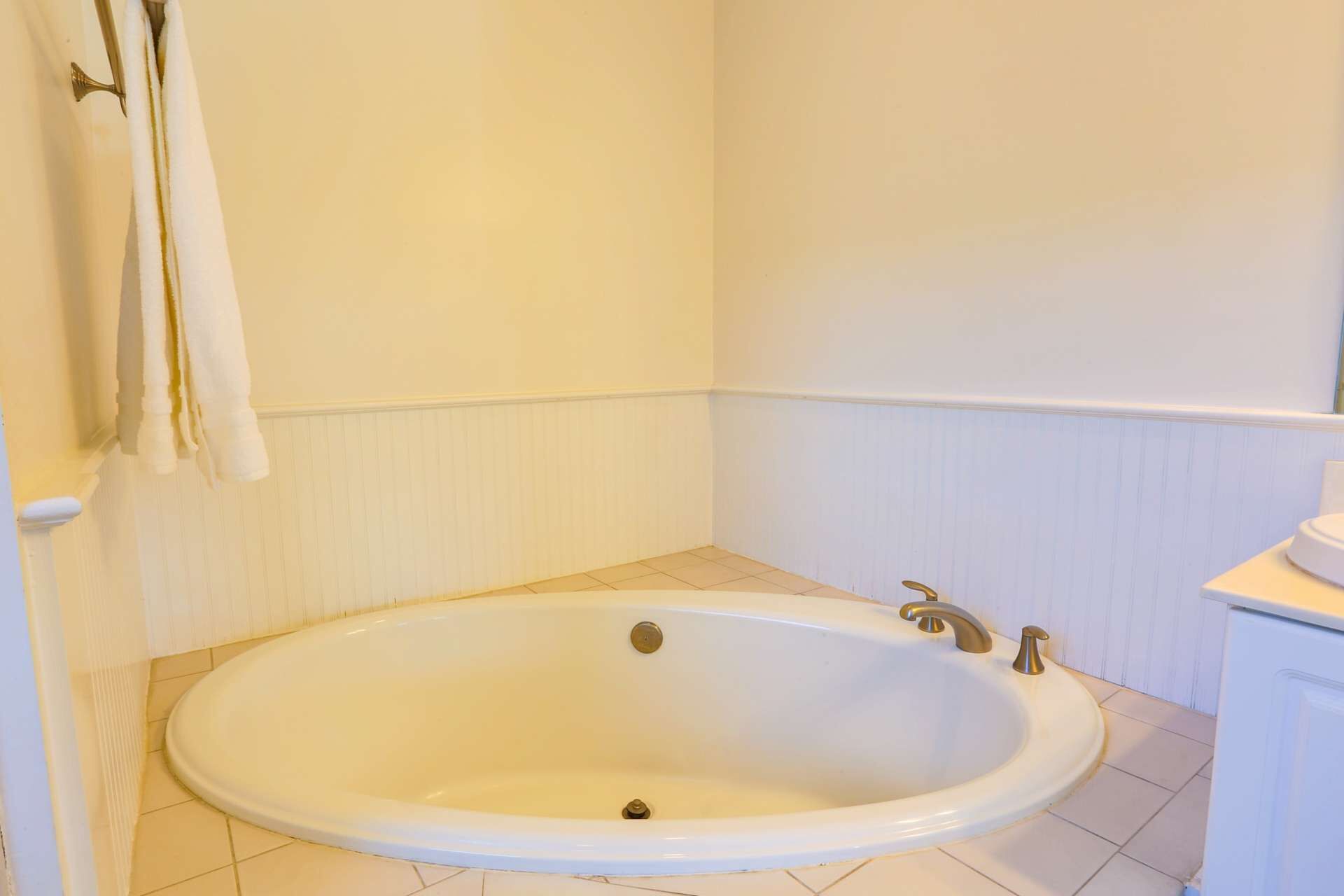 Une salle de bain avec une baignoire blanche, un lavabo blanc et des toilettes blanches.
