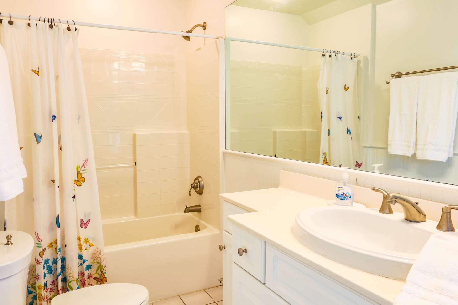 Une salle de bain avec une baignoire, des toilettes, un lavabo et un miroir.