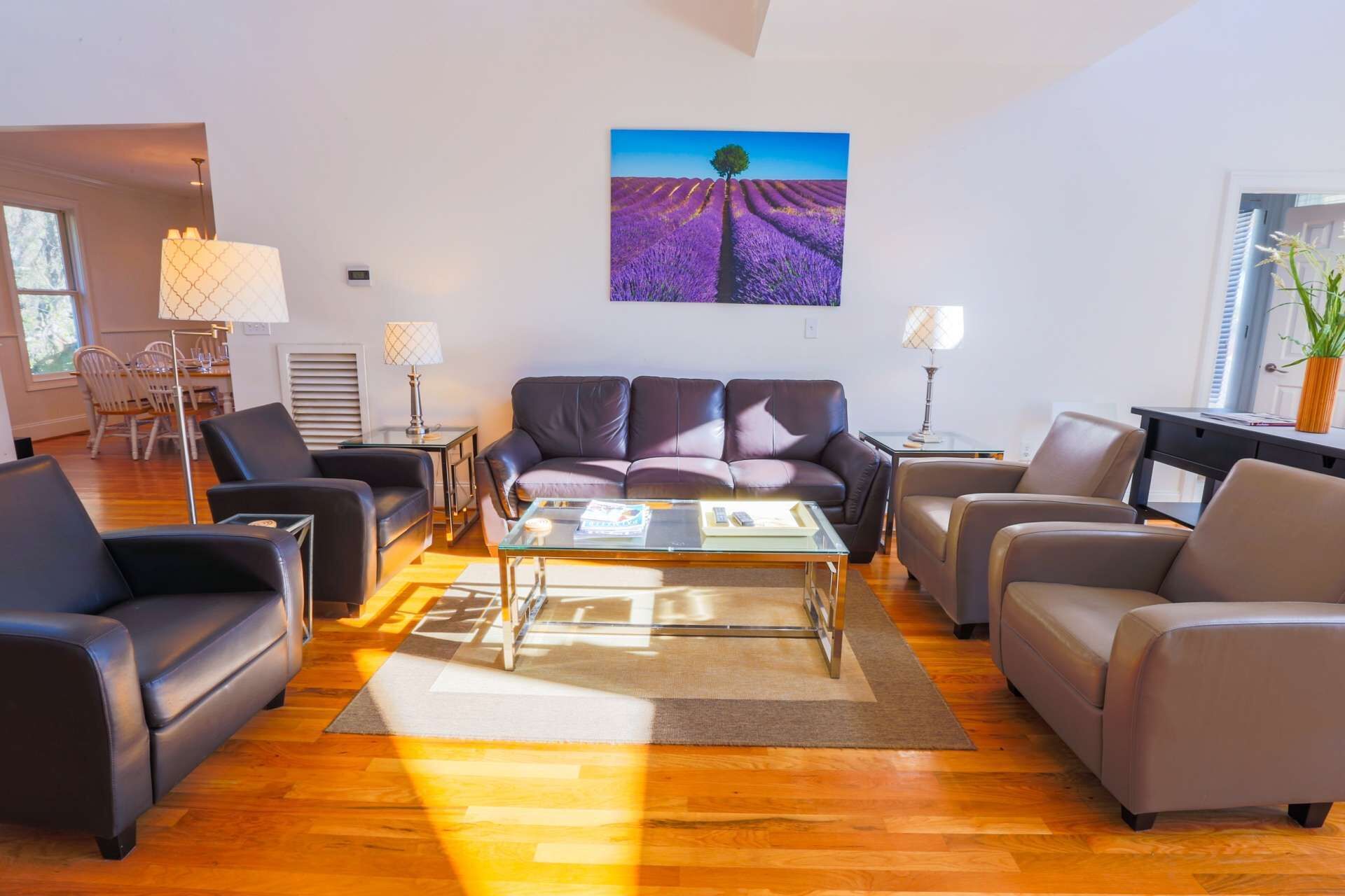 Een moderne woonkamer met een zithoek, een salontafel en een schilderij van lavendelvelden aan de muur.