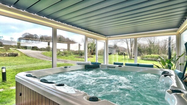 Un jacuzzi con vistas a un área verde y un sendero.