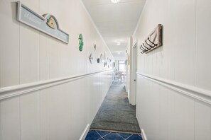 A hallway with a welcome sign, a crocodile decoration, and a wooden sign with black letters. - XPLORIE ACTIVITIES & LINENS INCLUDED*! OUTDOOR POOL (IN SEASON), TENNIS & MORE!!! (Ocean City)