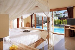 A bedroom with a bed, a bedside table, a TV, and a view of a swimming pool. - 3 Bedrooms Central Seminyak (Seminyak)
