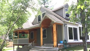 A two-story house with a porch, a covered front entrance, and a small front yard. - Booking for next summer. (Center Ossipee)