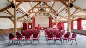 A large hall with a high ceiling and wooden beams, arranged with rows of chairs for an event.