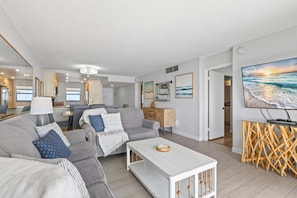 Een moderne woonkamer met een bank, salontafel en een televisie op een houten meubel.