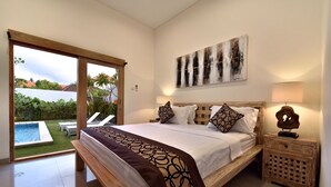 A bedroom with a large bed, a view of a swimming pool, and a wooden nightstand with a lamp. - 3Bedrooms Central Seminyak walking distance to the Boutique shop,Restaurant,Bar (Seminyak)