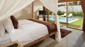A bedroom with a bed, a TV, and a view of a swimming pool. - 3Bedrooms Central Seminyak walking distance to the Boutique shop,Restaurant,Bar (Seminyak)