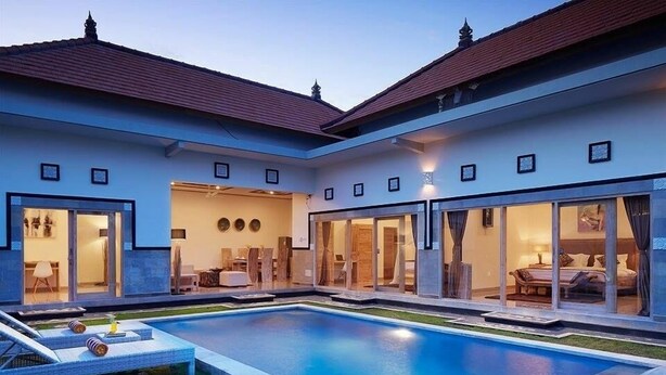 A modern house with a swimming pool, large glass doors, and a well-lit interior. - 3Bedrooms Central Seminyak walking distance to the Boutique shop,Restaurant,Bar (Seminyak)