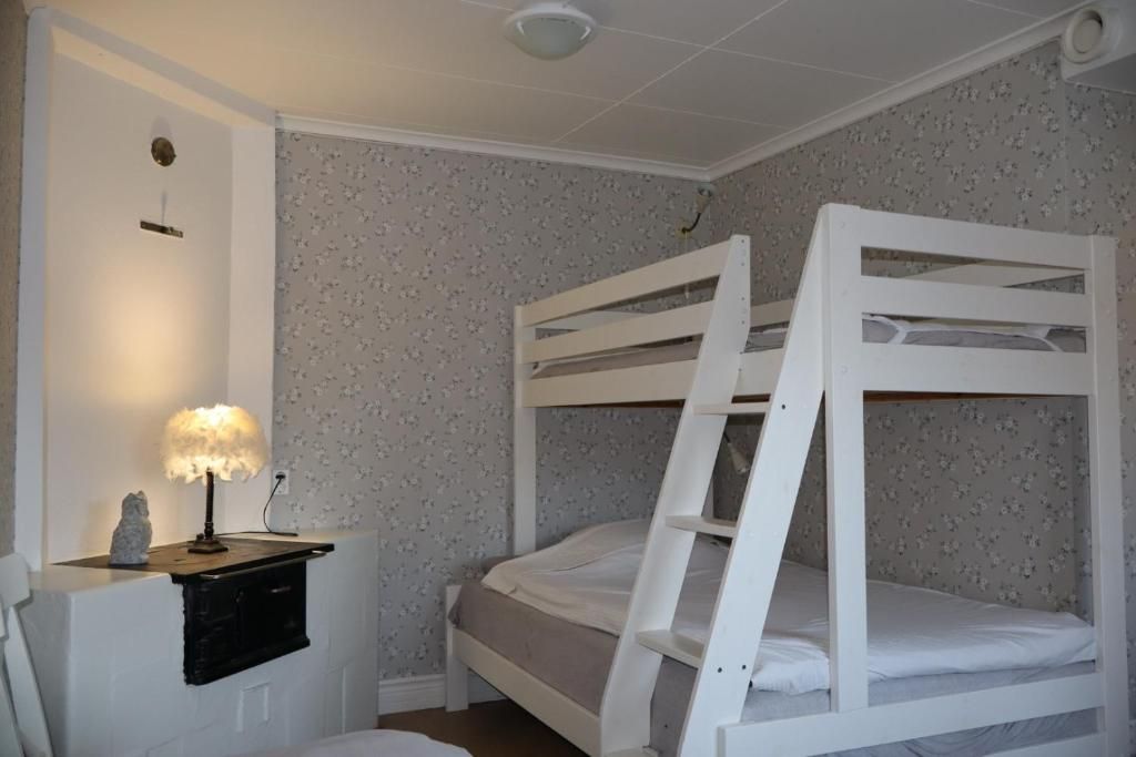 A bunk bed room with a nightstand and a lamp.