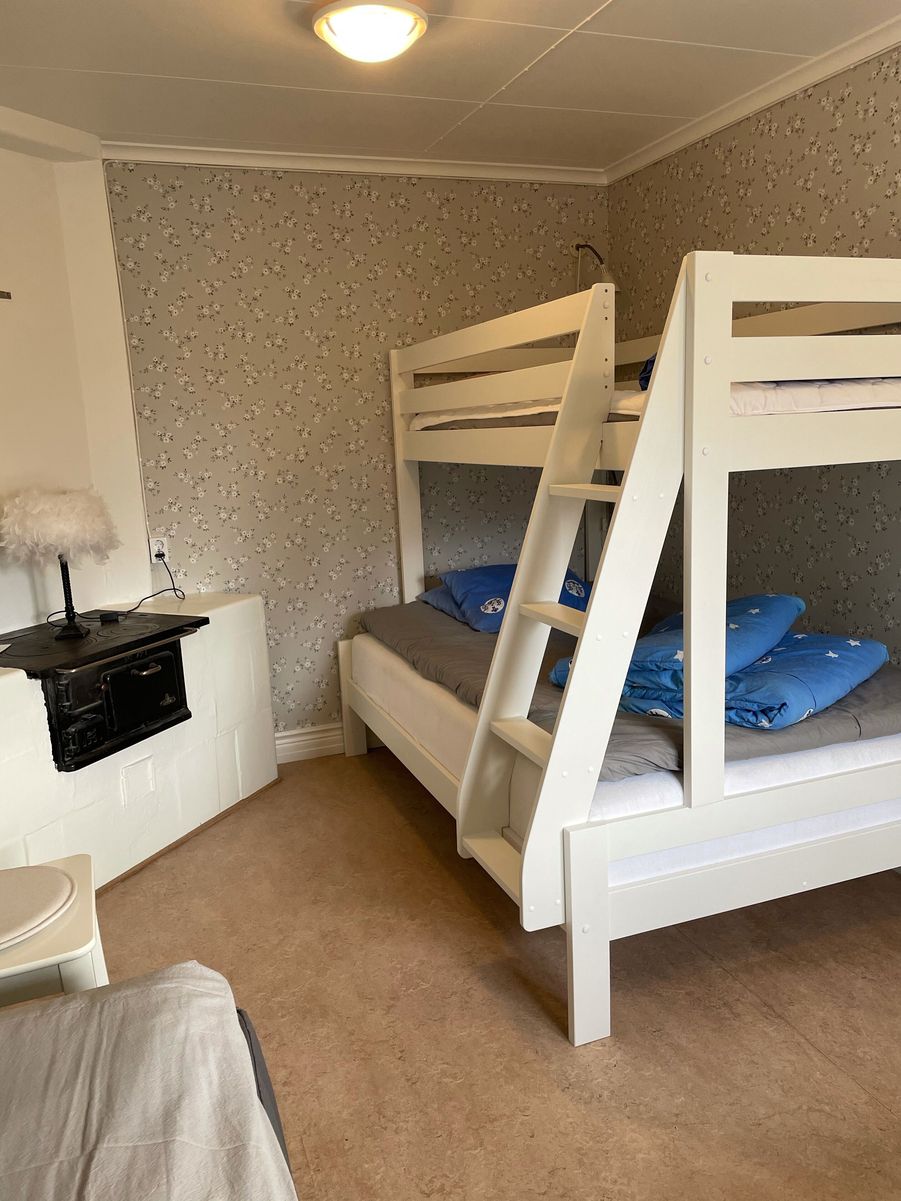 Une chambre avec un lit superposé, un bureau et une lampe.