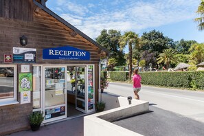 A reception area with a wooden facade, a blue sign, and a glass door.