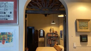 A cozy bedroom with a checkered floor, a bed with a patterned pillow, a bookshelf, and a wooden ceiling. - Quaint Colonial Home in Old San Juan (San Juan)