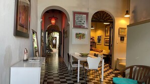 A hallway with a checkered floor, white furniture, and framed artwork. - Quaint Colonial Home in Old San Juan (San Juan)