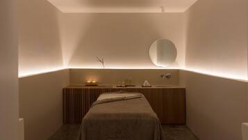 A modern bathroom with a wooden vanity, a round mirror, and a towel draped over a bench.