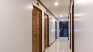 A hallway with wooden doors and white walls. - Suthep Home & Hostel (Bangkok)