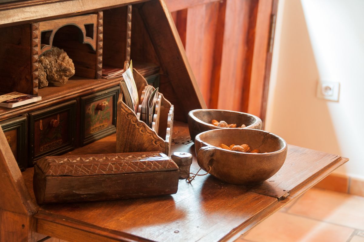 A wooden table with a bowl, a small container, and a decorative box.