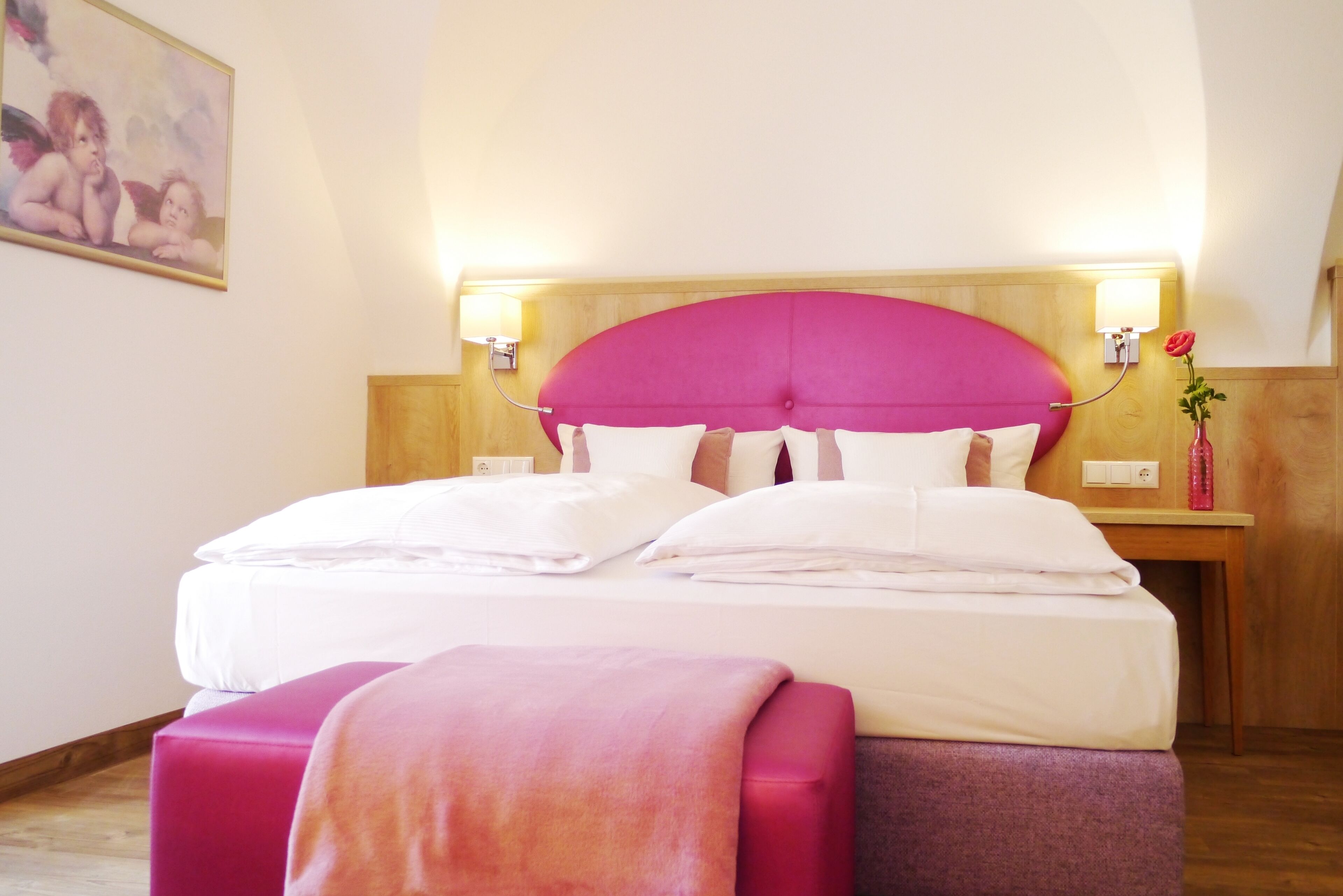 Ein Hotelzimmer mit einem großen Bett, einem Holzkopfteil, Nachttischen und einem Bild an der Wand.