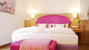 Ein Hotelzimmer mit einem großen Bett, einem Holzkopfteil, Nachttischen und einem Bild an der Wand.