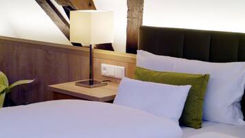 Une chambre d’hôtel avec un lit, une table de chevet avec une lampe et une tête de lit en bois.