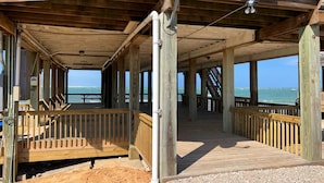 A wooden deck with a view of the ocean, a satellite dish, and a sign indicating a number. - Atlantis - Oceanfront Seating at its Finest! (Freeport)