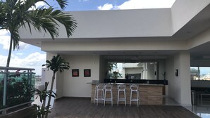 Una cocina moderna con barra, piso de madera y vistas a la ciudad.