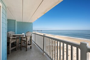 A balcony with a view of the beach and ocean. - First Light: PierView Oceanfront Condo, Contemporary Vibes & Stunning Views (Nags Head)