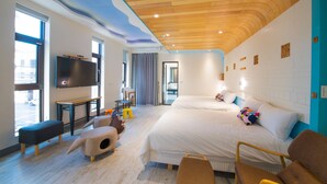 Habitación de hotel moderna con una cama grande, televisión, escritorio y una casita para gatos.