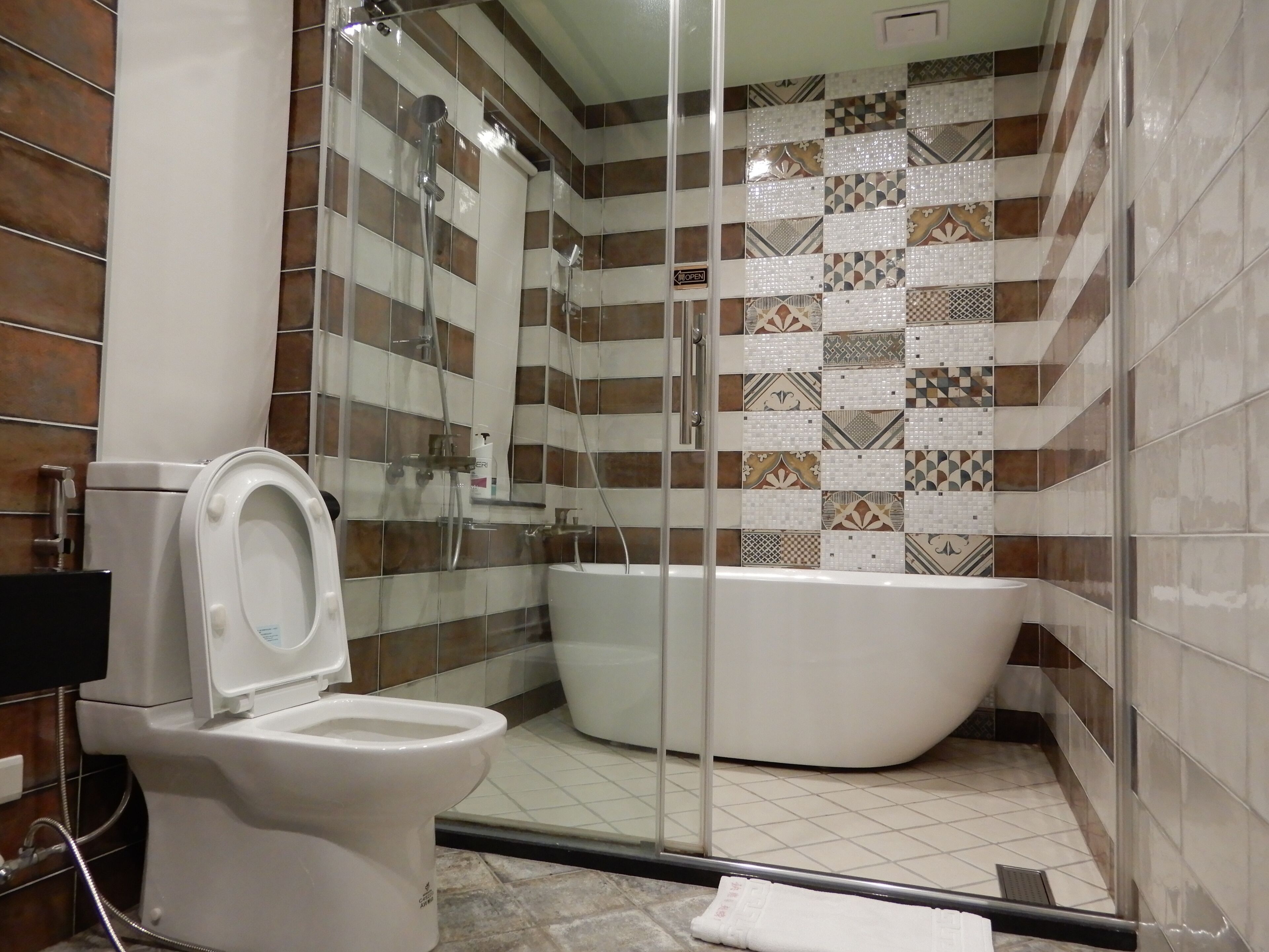 A bathroom with a toilet, a shower, and a bathtub.
