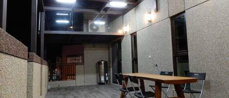 Une salle de conférence équipée d’une longue table et de chaises, d’un distributeur d’eau et d’un ventilateur de plafond.