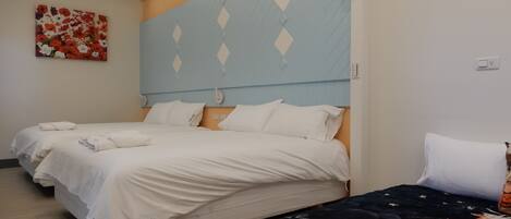 A hotel room with two beds, a large wall mural, and a patterned headboard.