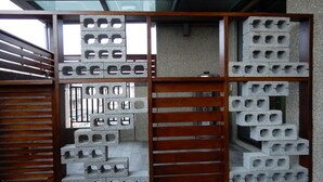 Un interior moderno con techo de vidrio, listones de madera y bloques de hormigón dispuestos en un diseño decorativo.