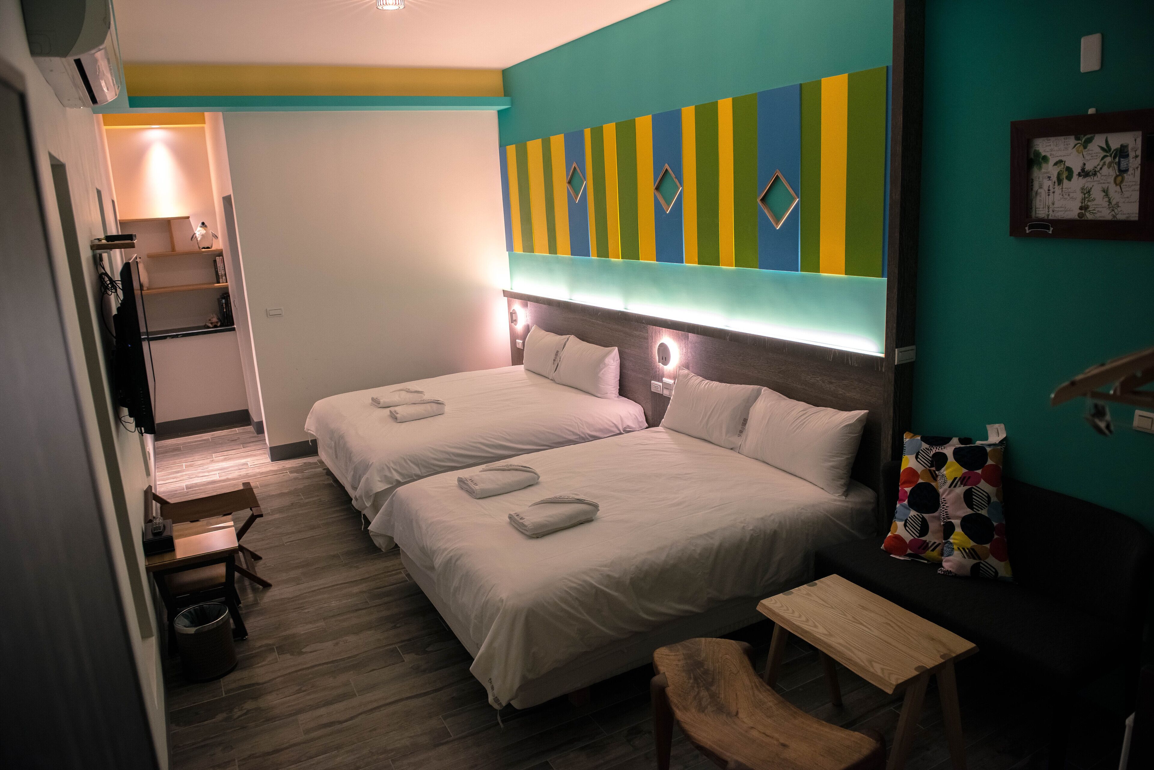 Une chambre d’hôtel avec deux lits, un bureau, une chaise et une petite table.