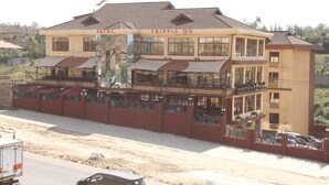 Un hotel de dos pisos con balcones y un letrero que dice "TRIPPLE O'S HOTEL".