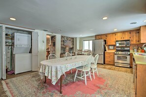 A kitchen with a dining table, chairs, and various appliances including a refrigerator, microwave, and oven. - Historic Bradford Home - 8 Mi to Mount Sunapee! (Bradford)