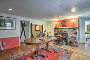 A dining area with a round table, a fireplace, and a red carpet. - Historic Bradford Home - 8 Mi to Mount Sunapee! (Bradford)